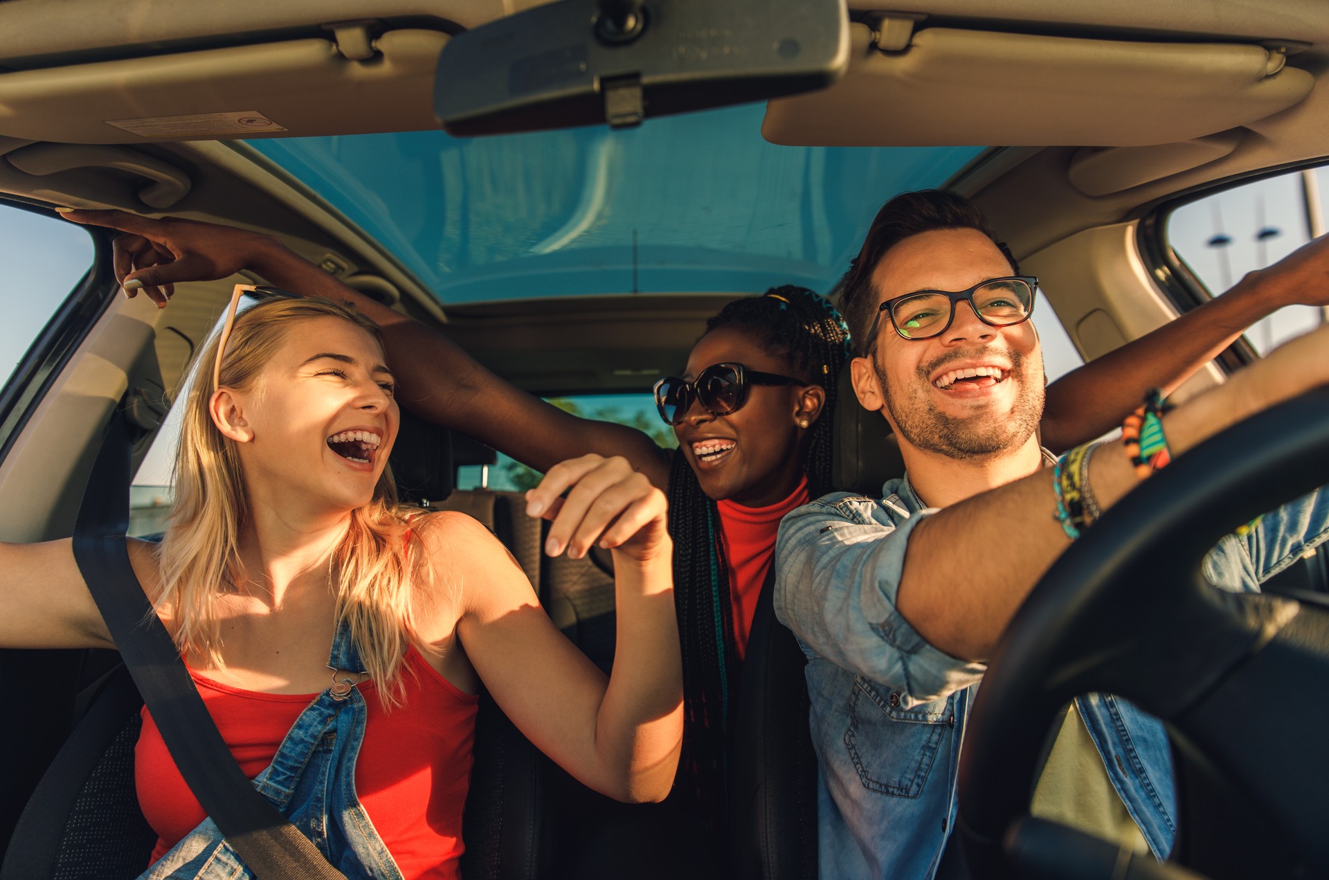 Tre migliori amici che si divertono a viaggiare in vacanza in macchina.